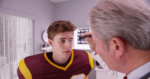  Un jugador de fútbol americano está siendo revisado por una conmoción cerebral.