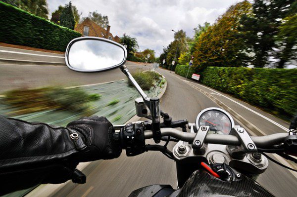 Una motocicleta conduciendo por la carretera desde el punto de vista del conductor.