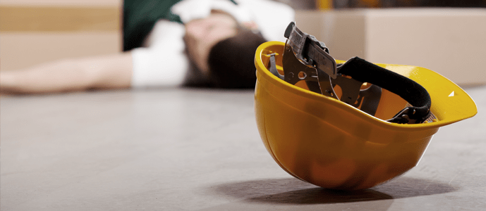 An industrial worker lies injured at work