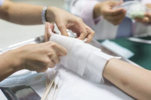 A nurse treats a victim's burned hand
