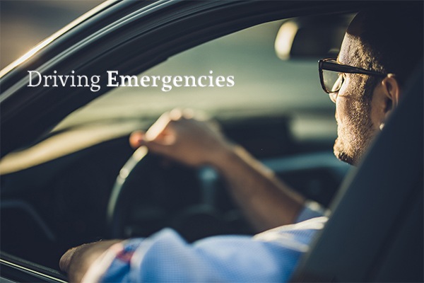 A man sitting in a car driving beside the words "Driving Emergencies"