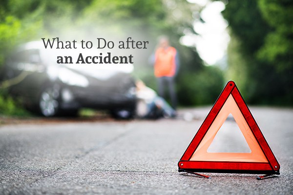 An orange triangular traffic hazard indicator with a car crash in the background with the words what to do after an accident