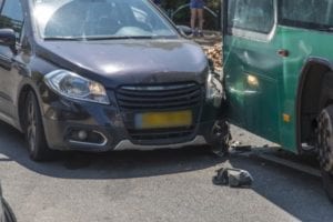 A car has rear-ended a commercial bus.