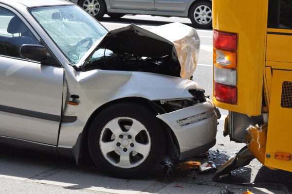 A car has rear-ended a school bus.