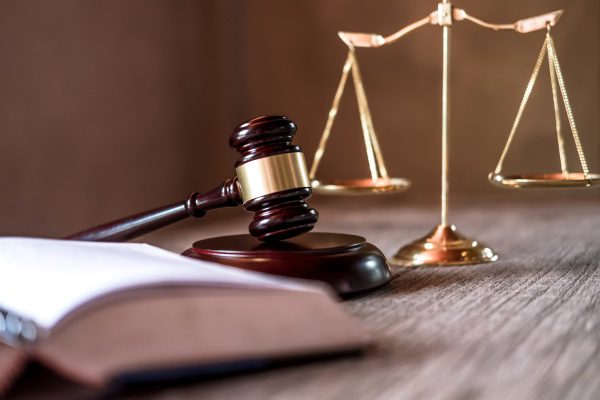 A book, a gavel, and a pair of legal scales.