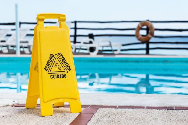 A caution when wet sign sits in front of a pool.