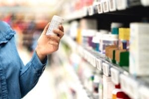A consumer is checking a warning label on a bottle of pills. 