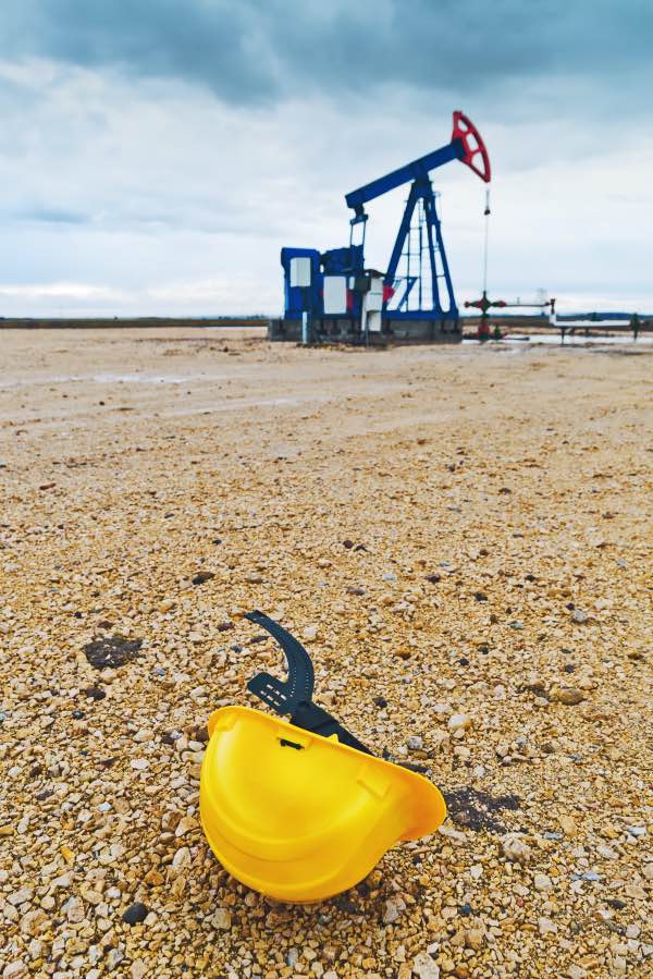 A safety helmet in front of an oilfield