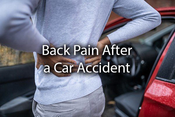 A person holding their back in pain after a car accident with the words, back pain after a car accident.