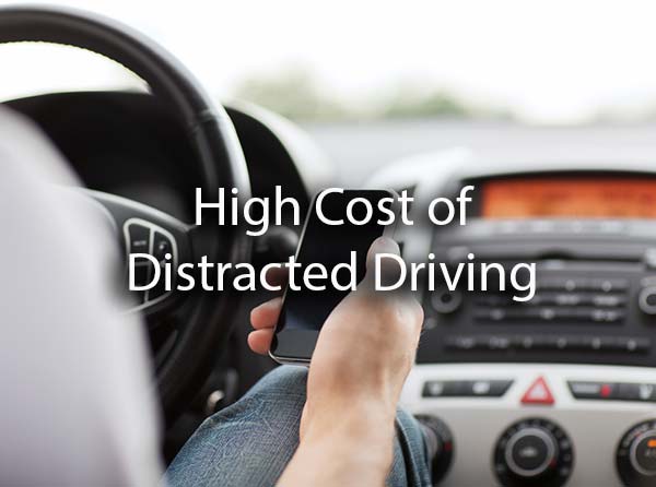 A man checking his phone while driving with the words, high cost of distracted driving.
