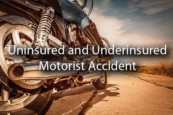 A motorcycle on the road with the words, uninsured and underinsured motorist accident.