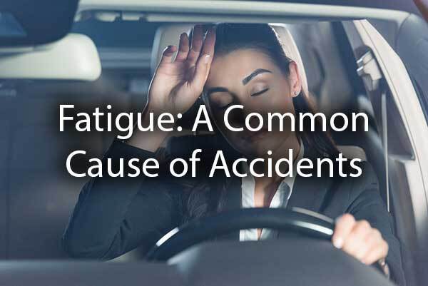 A lady is tired while driving with the words, "Fatigue: a common cause of accidents."