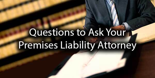 An attorney going over paperwork with the words "questions to ask your premises liability attorney."