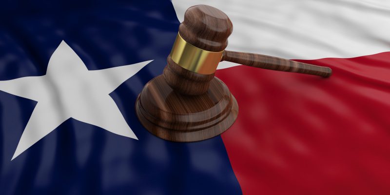 A gavel with the Texas flag underneath.