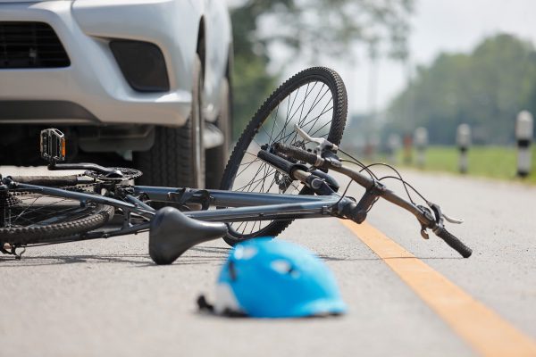 A shot of a bicycle accident with a helmet laying in the road.